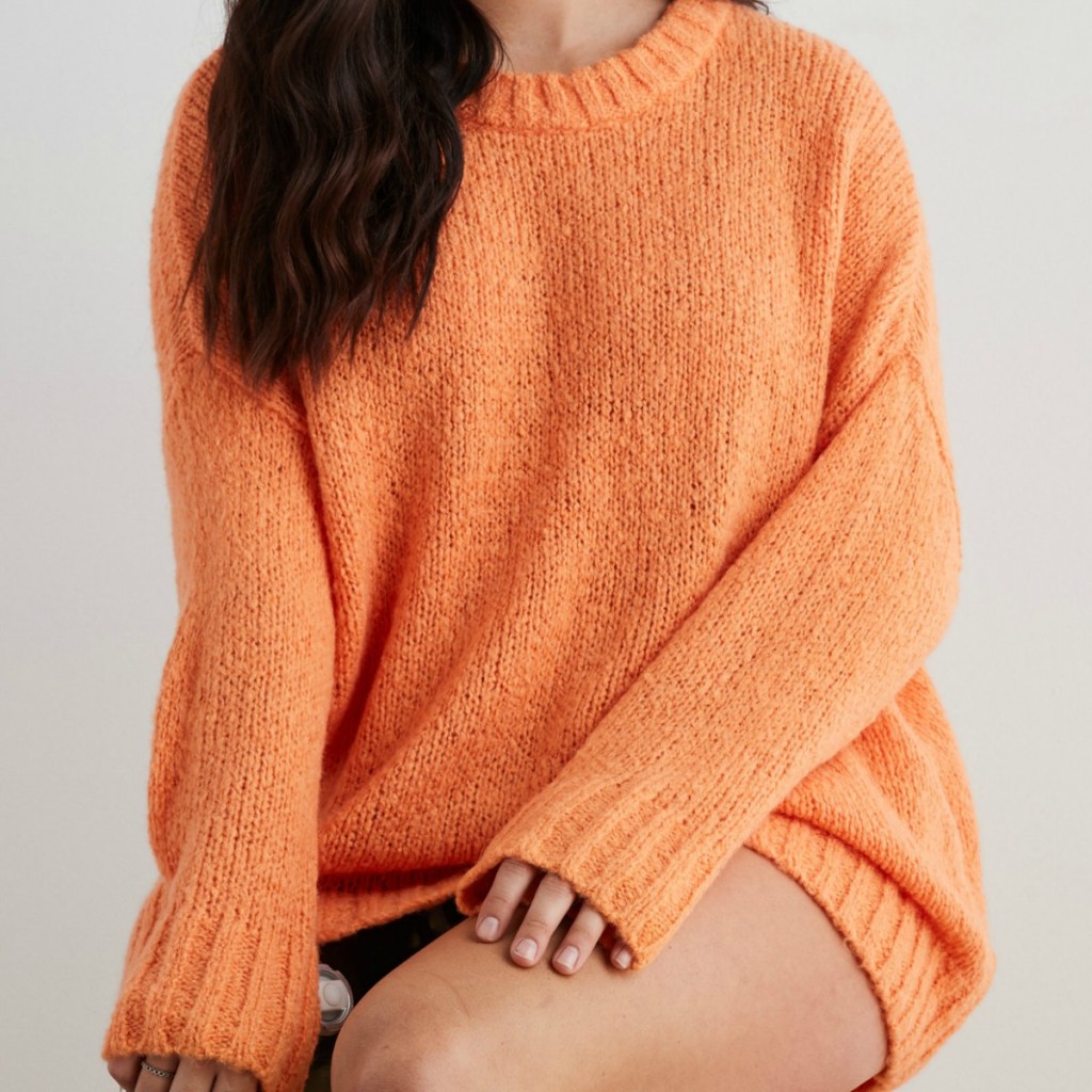 Woman wearing an orange oversized sweater