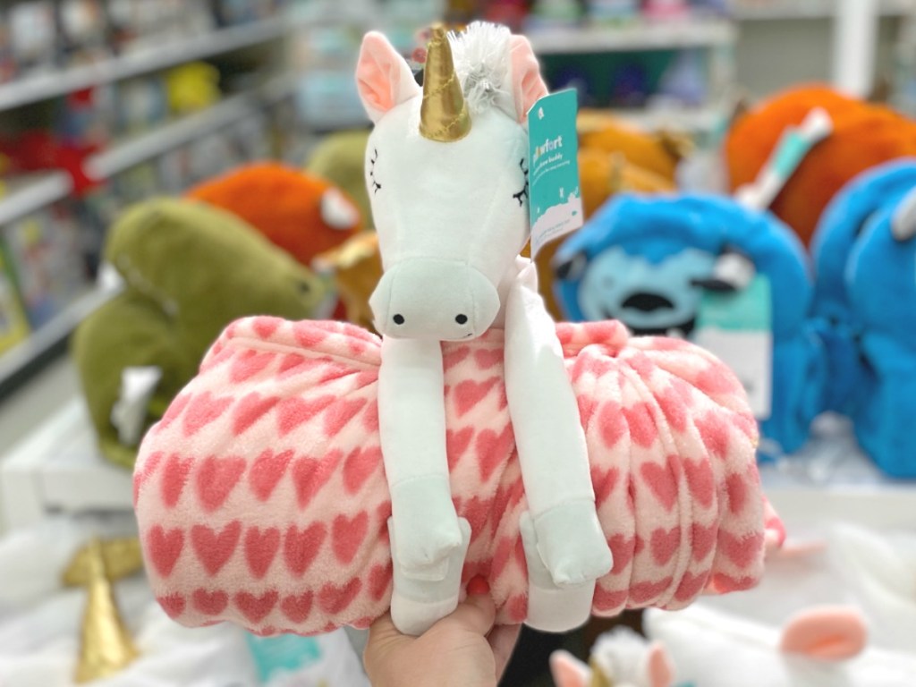 Unicorn plush holding a heart throw blanket