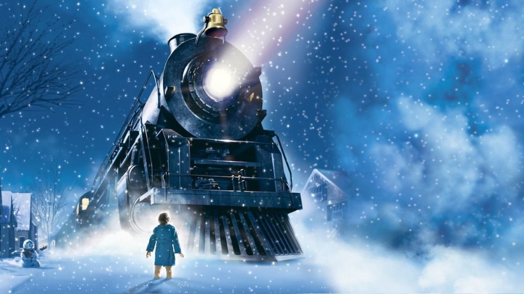 the polar express train outside with boy standing in snow
