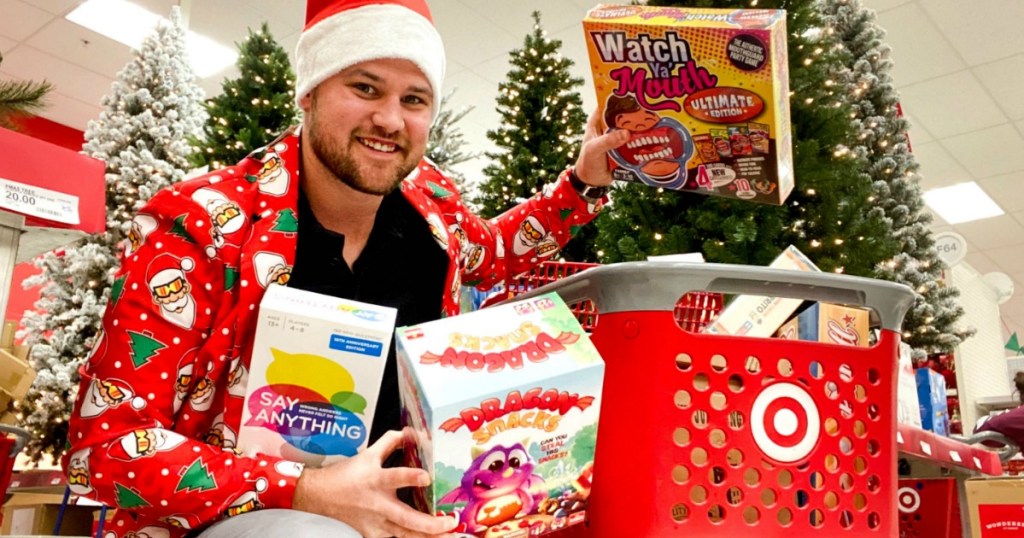 Man shopping in Target with board games near Christmas Trees