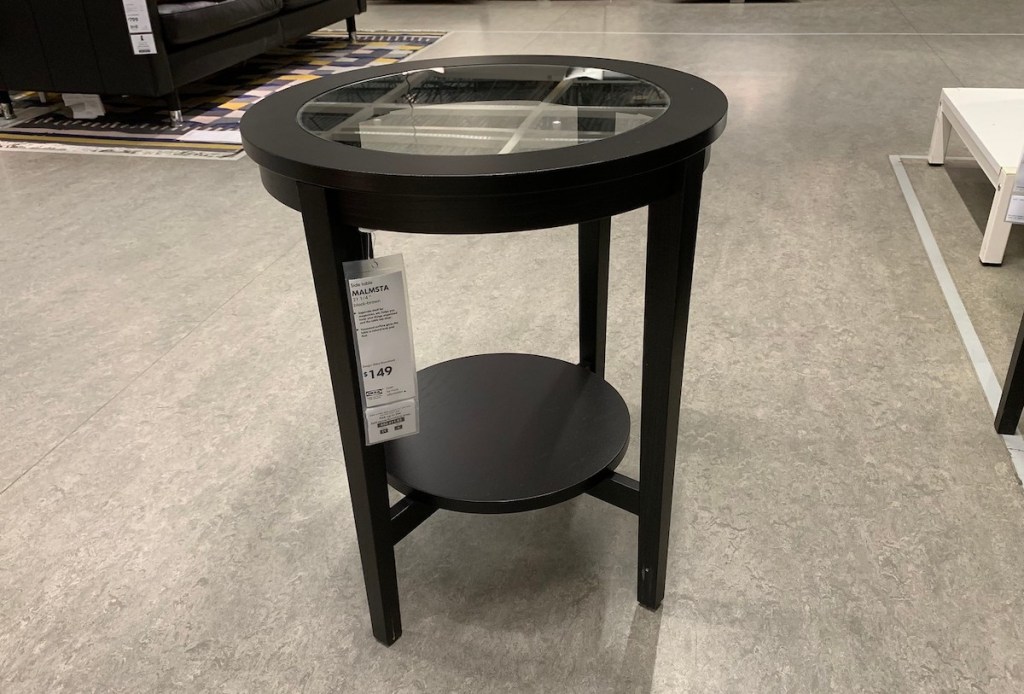round black table with glass in the middle sitting on store floor