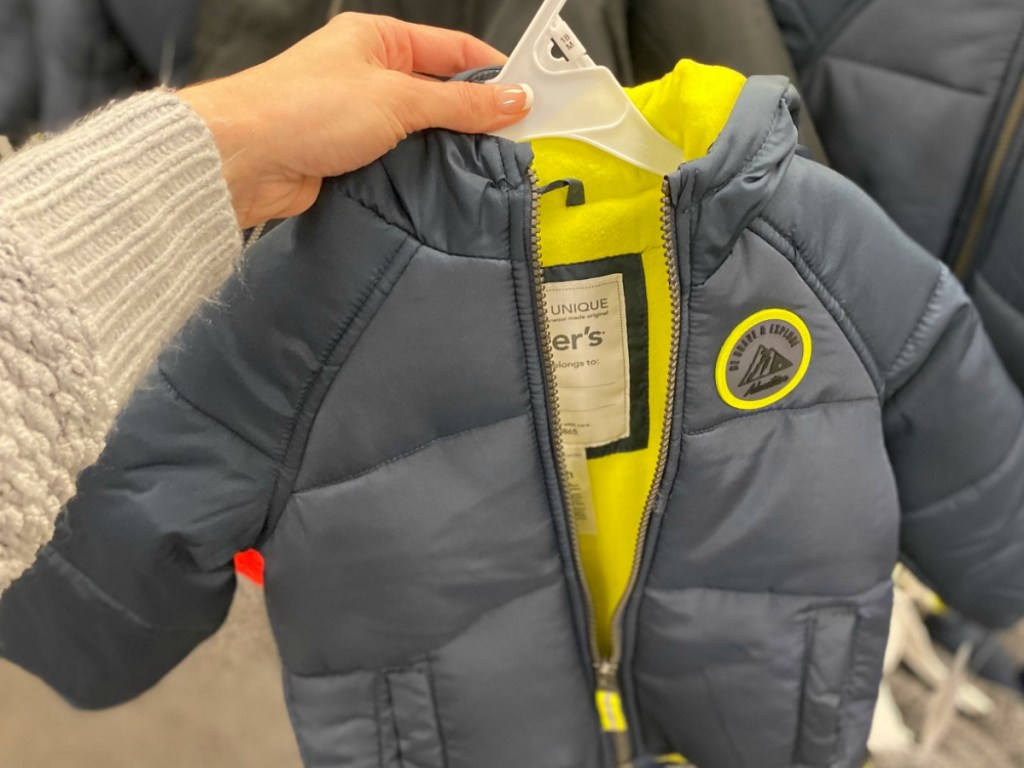 hand holding grey small kids jacket in store
