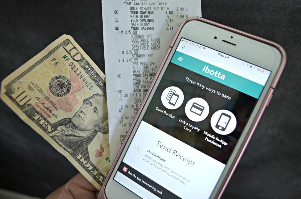 ibotta app on phone next to receipt and $10 bill