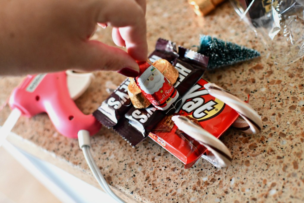 hot gluing a candy santa sleigh