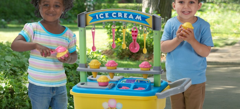 two kids by plastic ice cream cart