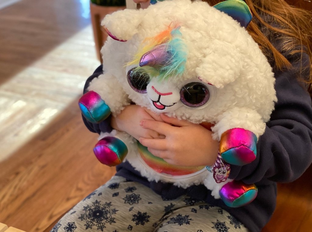 kid hugging plush rainbocorns stuffed animal