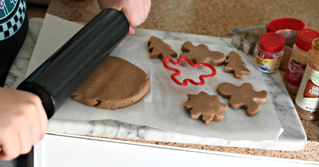 rolling gingerbread play dough on a cutting board