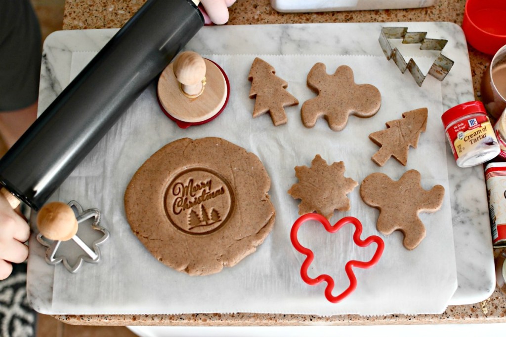 rolling out gingerbread play dough on a cutting board 