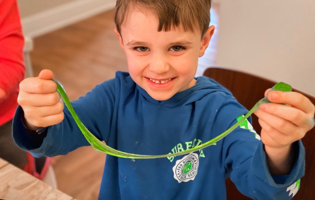 boy in blue shirt holding green slime 