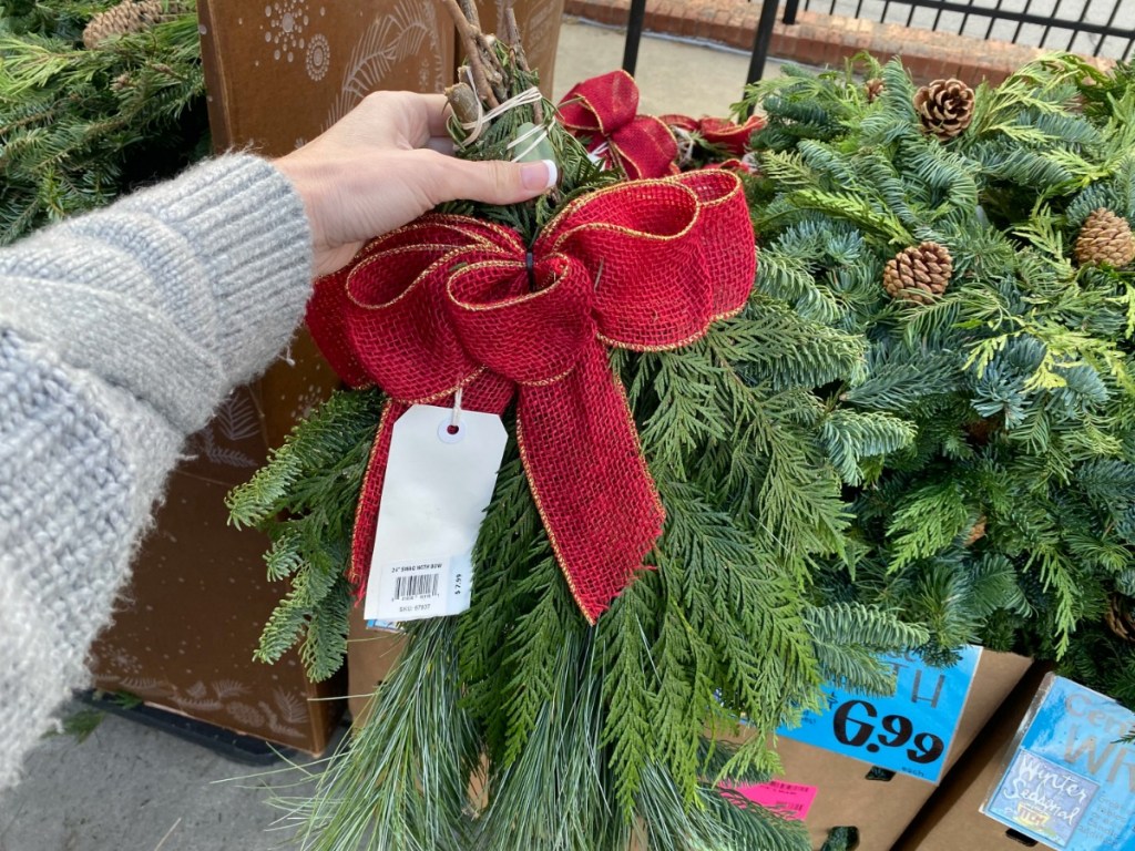 hand holding garland with red bow