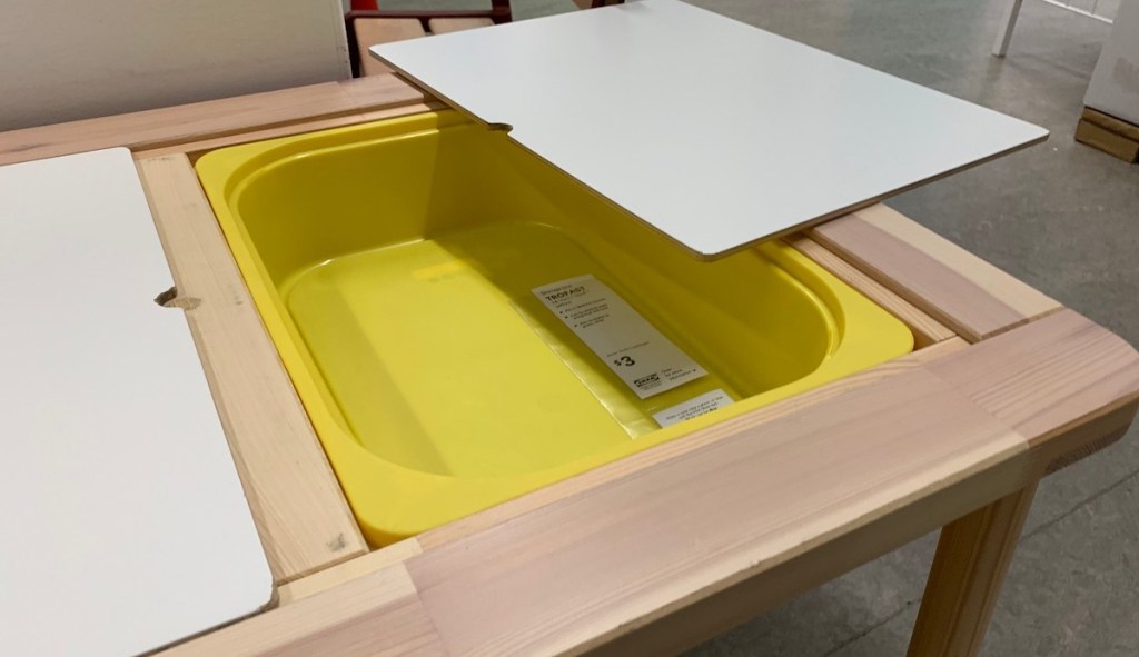 open table top with yellow plastic bin inside