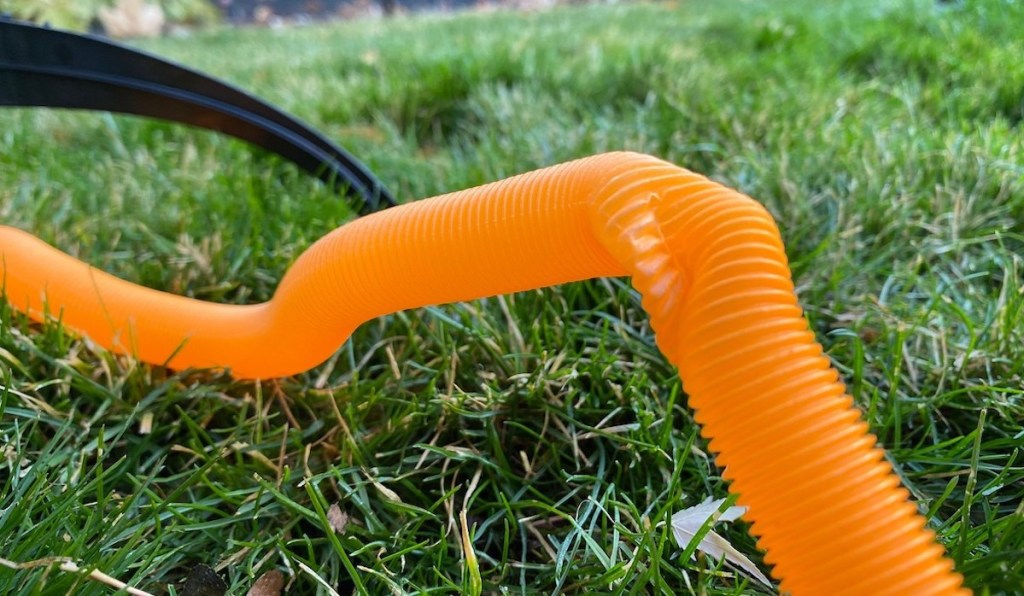 orange tube in grass with kink in it