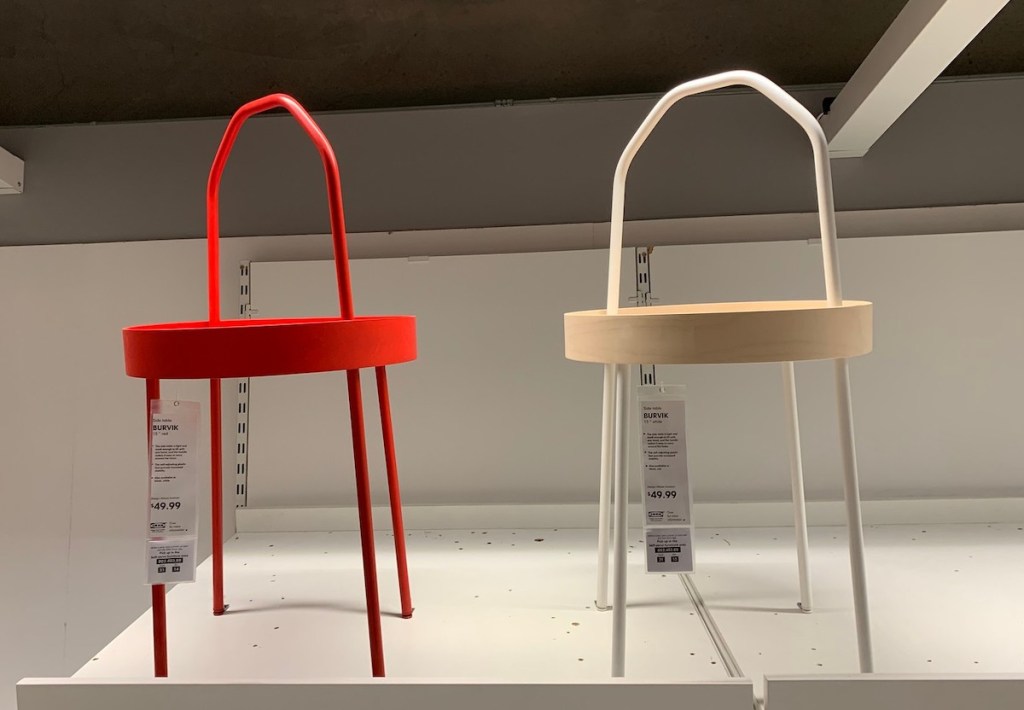 red and white natural wood side tables with handles on store shelf 