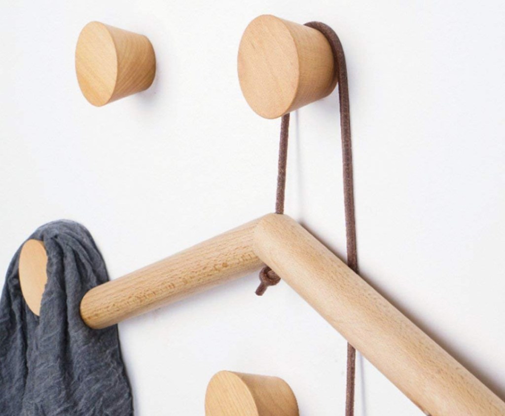 close up of natural wooden wall knobs with wooden hanger and scarf hanging