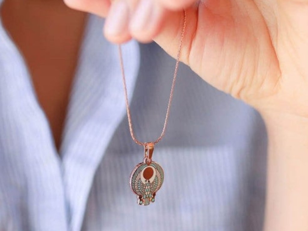 woman's hand holding alex and ani falcon necklace