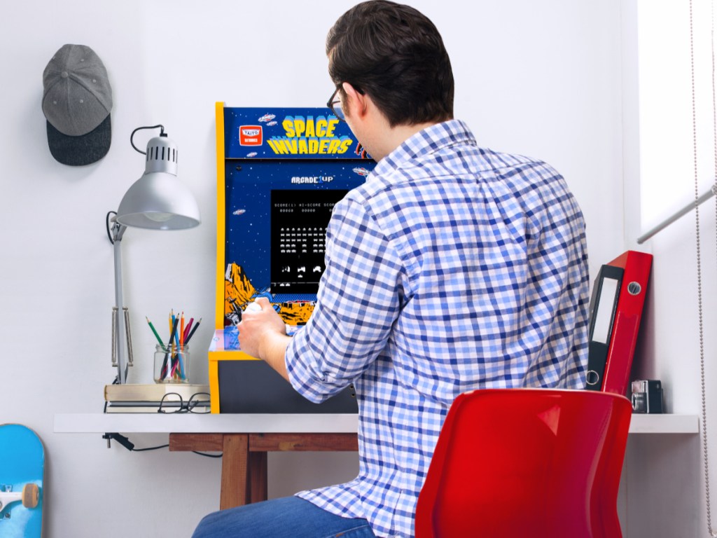 man playing space invaders counter arcade machine