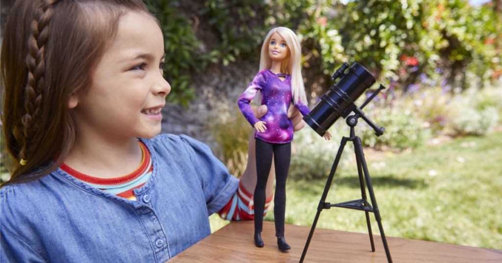 little girl playing with barbie outside