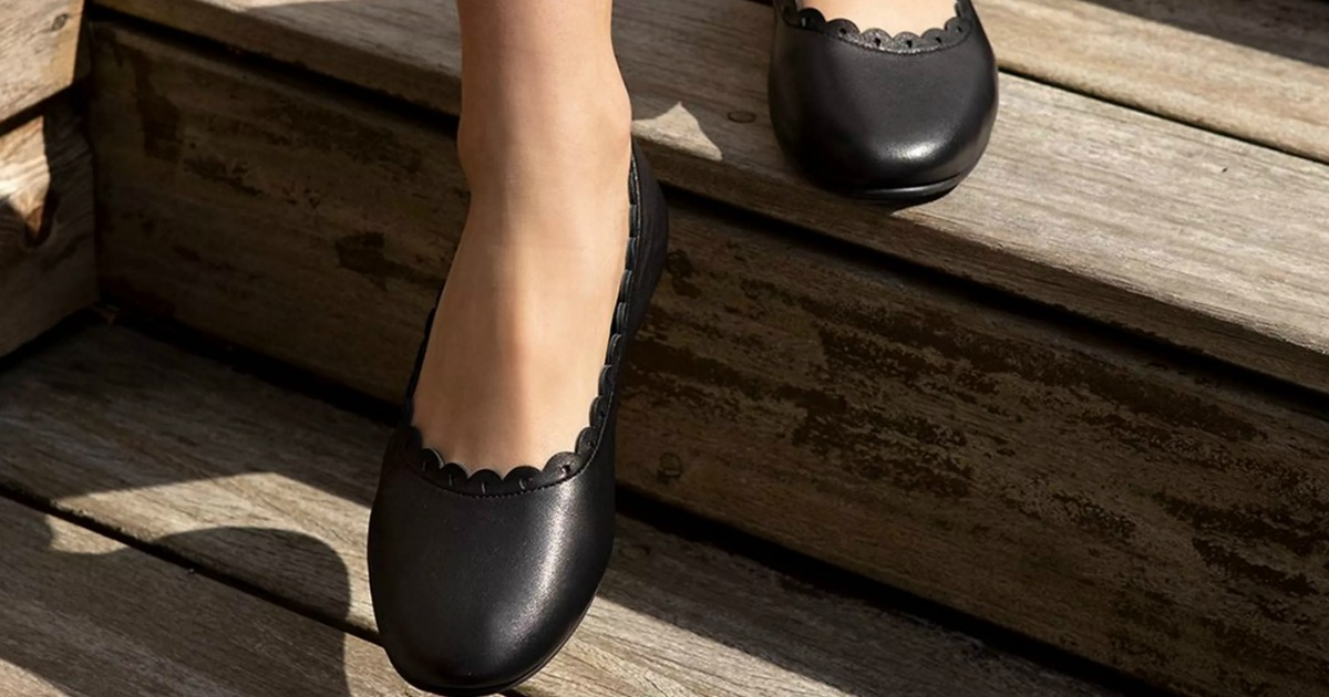Woman walking down wooden stairs in Women's black leather ballet flats