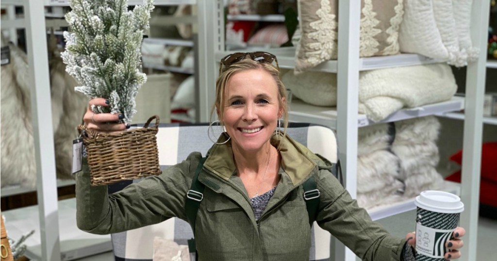 Woman holding small flocked Christmas tree at Target