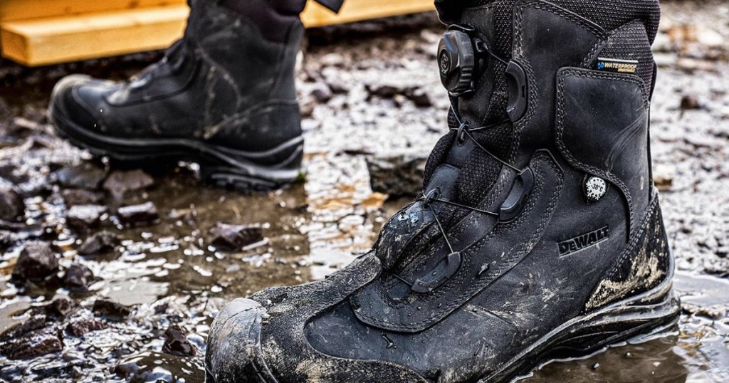 man wearing DeWalt work boots in the mud