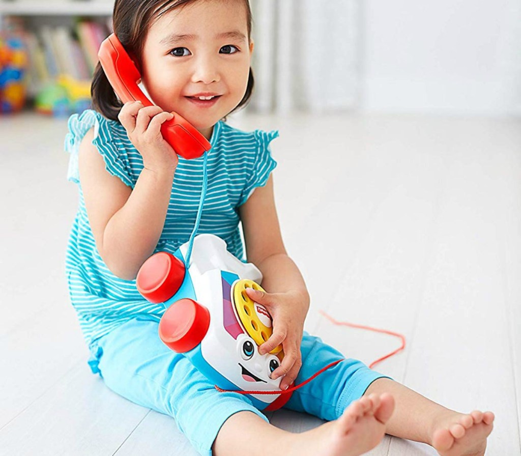 little girl playing with a Fisher-Price chatter telephone