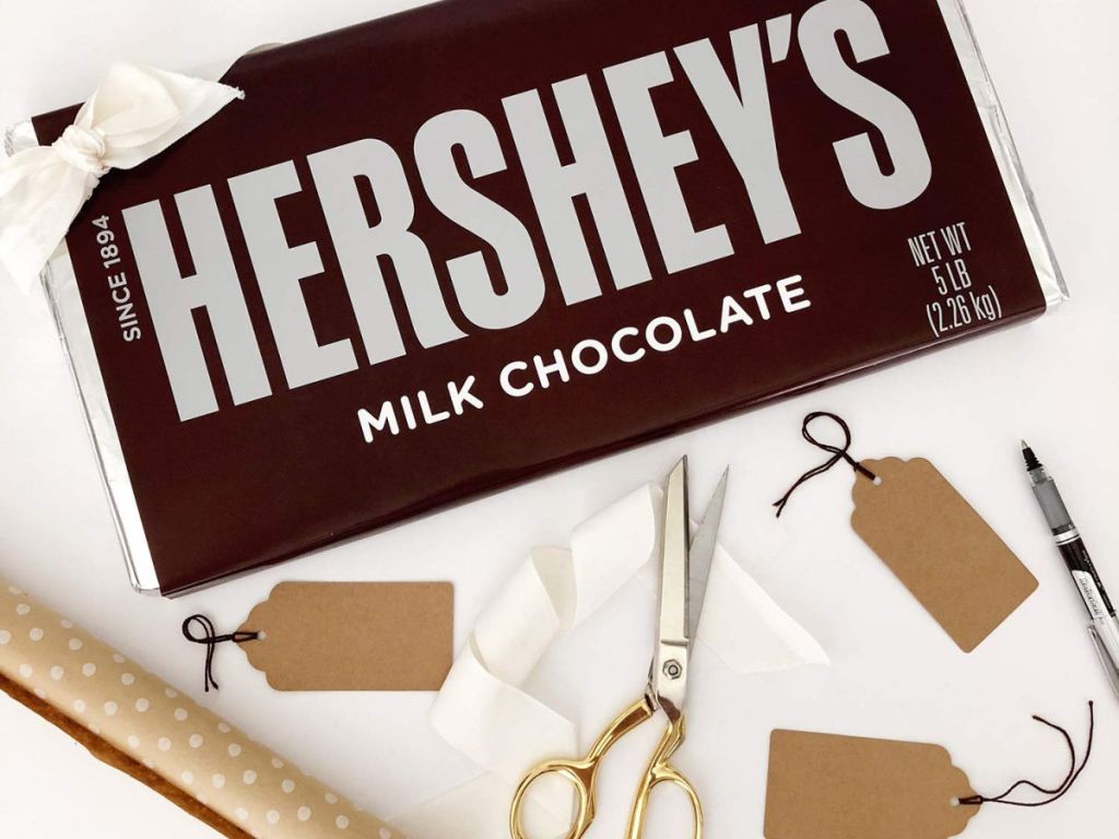 Giant hershey's 5 pound chocolate bar with gold scissors, gift tags, and wrapping paper