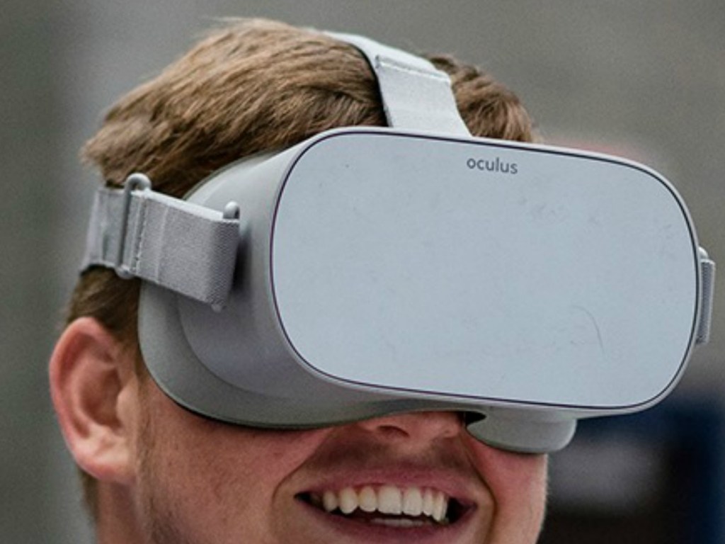 Man wearing an Oculus Go VR headset at a football game
