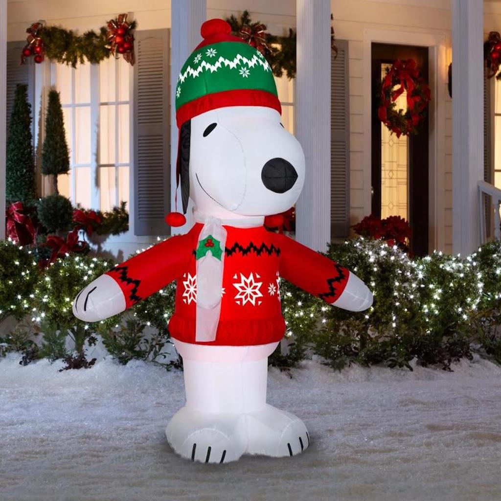 Peanuts Lighted Snoopy Christmas Inflatable in snowy yard in front of house