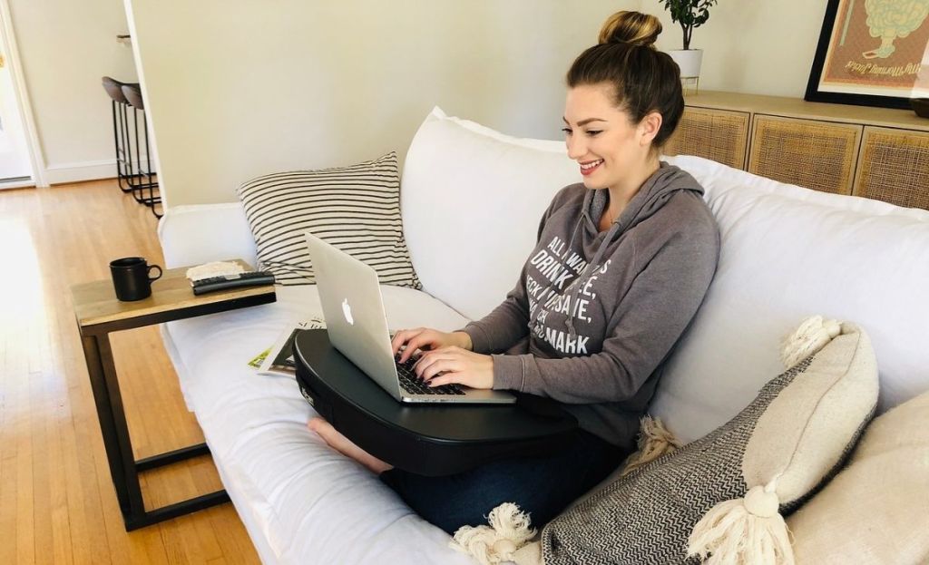 A woman sitting on a couch with a laptop