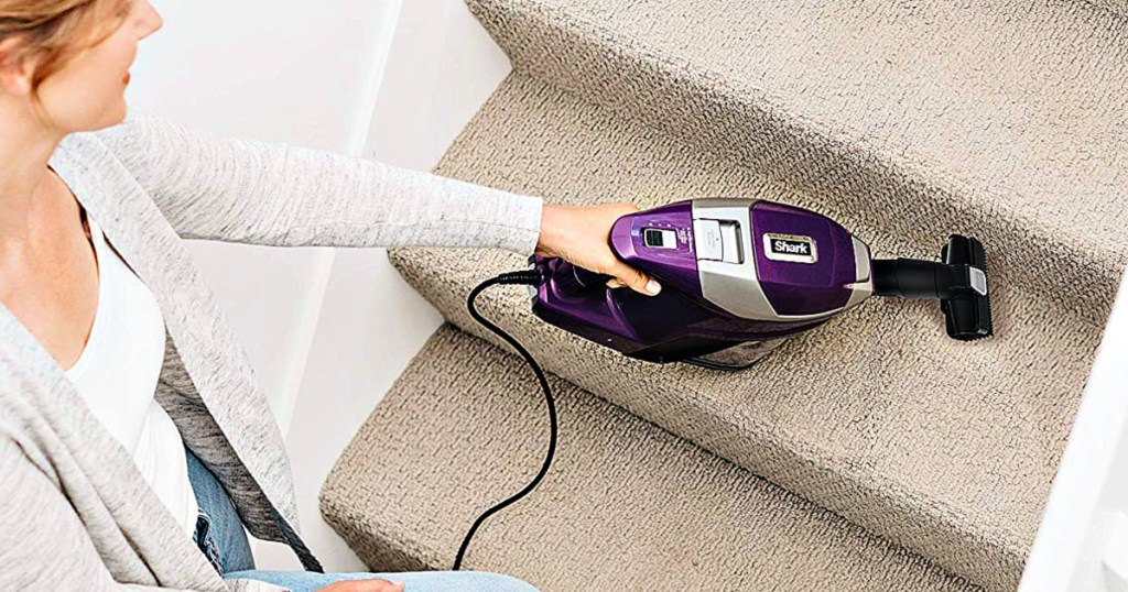 Shark Rocket Corded Ultra-Light Vacuum with Zero-M Anti-Hair Wrap Technology being used by woman on stairs