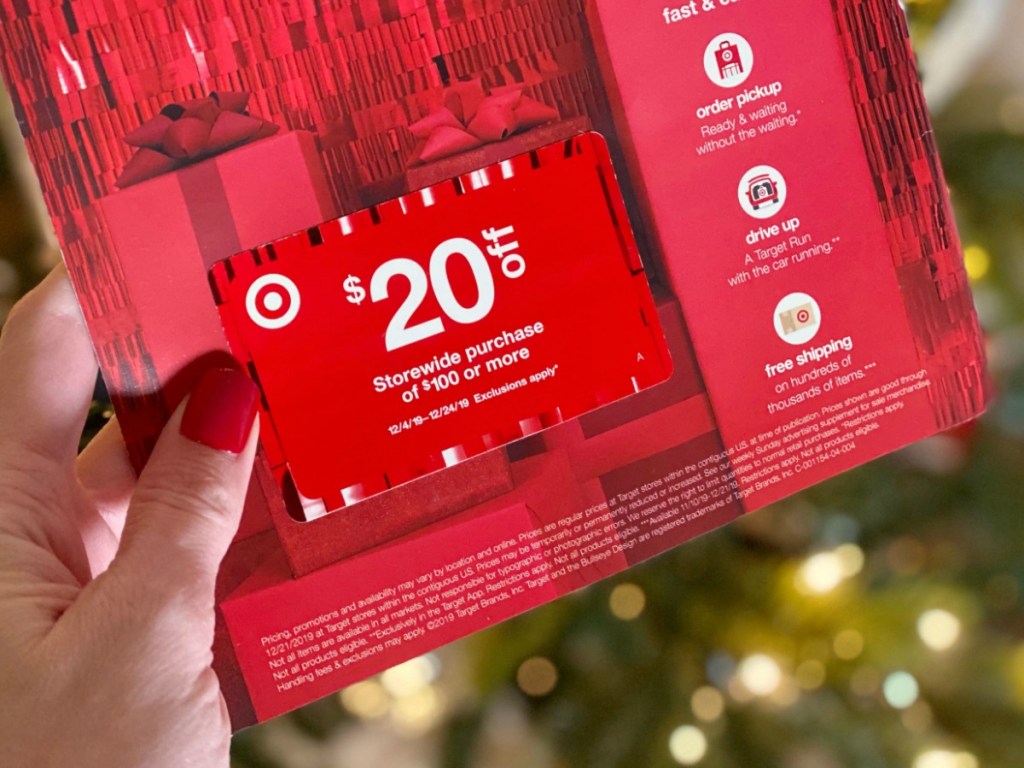 Woman holding Target Mailer Coupon in front of Christmas Tree