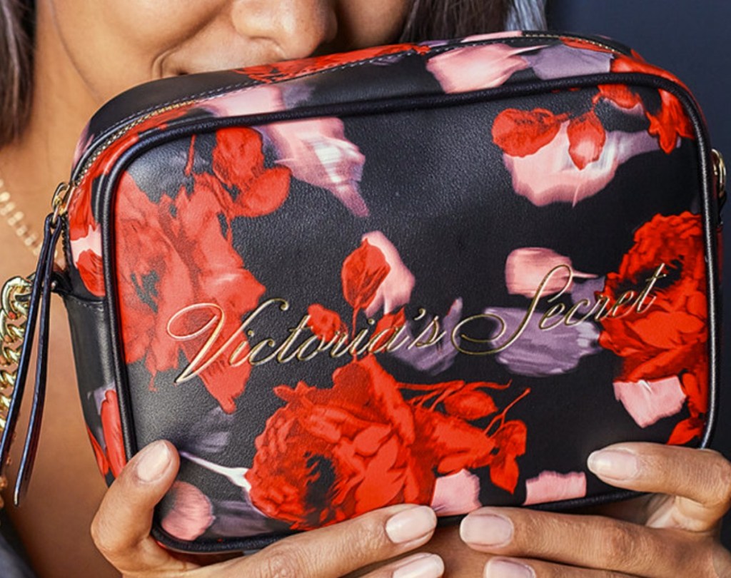 Woman holding a floral Victoria's Secret Crossbody Bag 