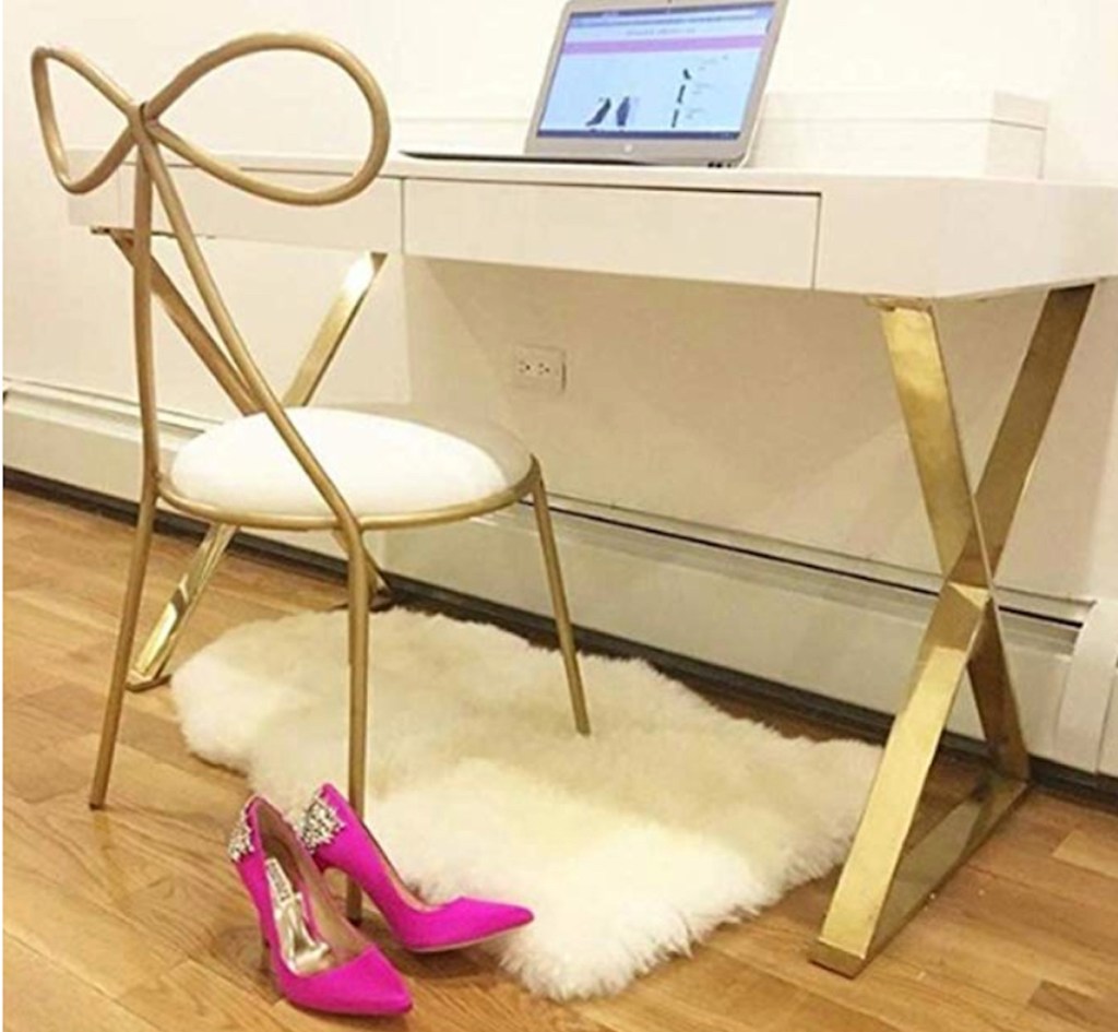 gold bow shaped chair and office desk with computer and hot pink high heels