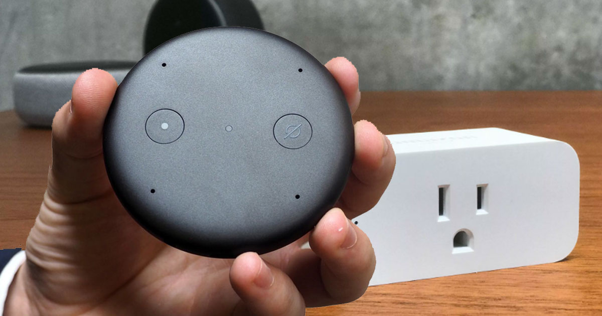 hand holding an Amazon Echo Input and an Amazon Smart Plug on the table