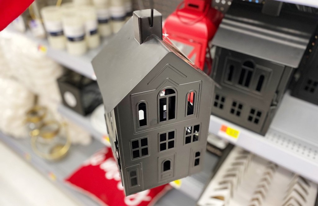 black house lantern in front of store shelf with candles and red decor