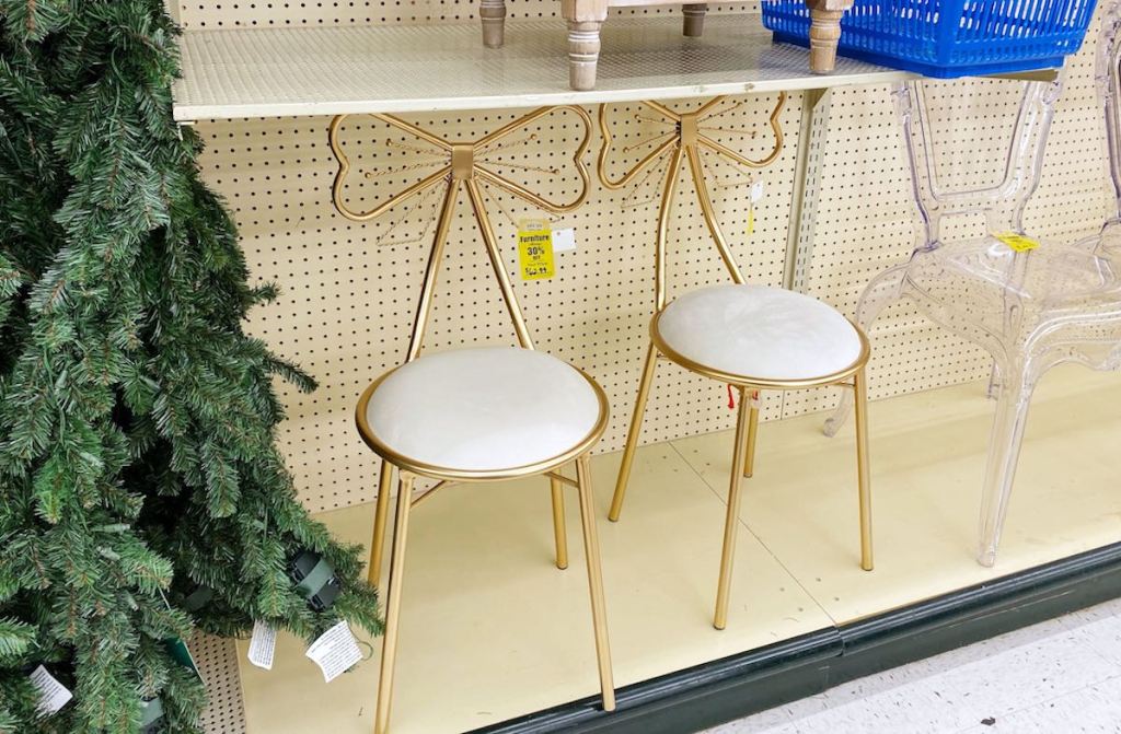 two gold bow chairs sitting on store shelf