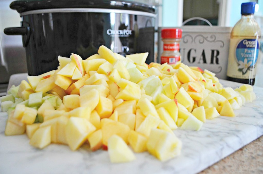 apples sitting in front of a crock-pot slow cooker