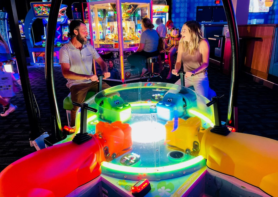 couple sitting on hungry hungry hippo game at dave and busters