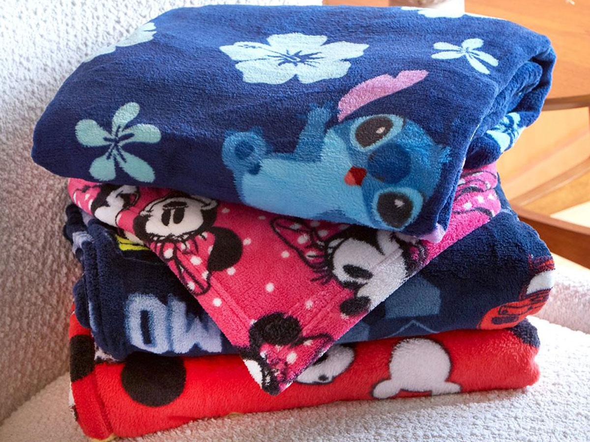 disney blankets stacked on a chair 