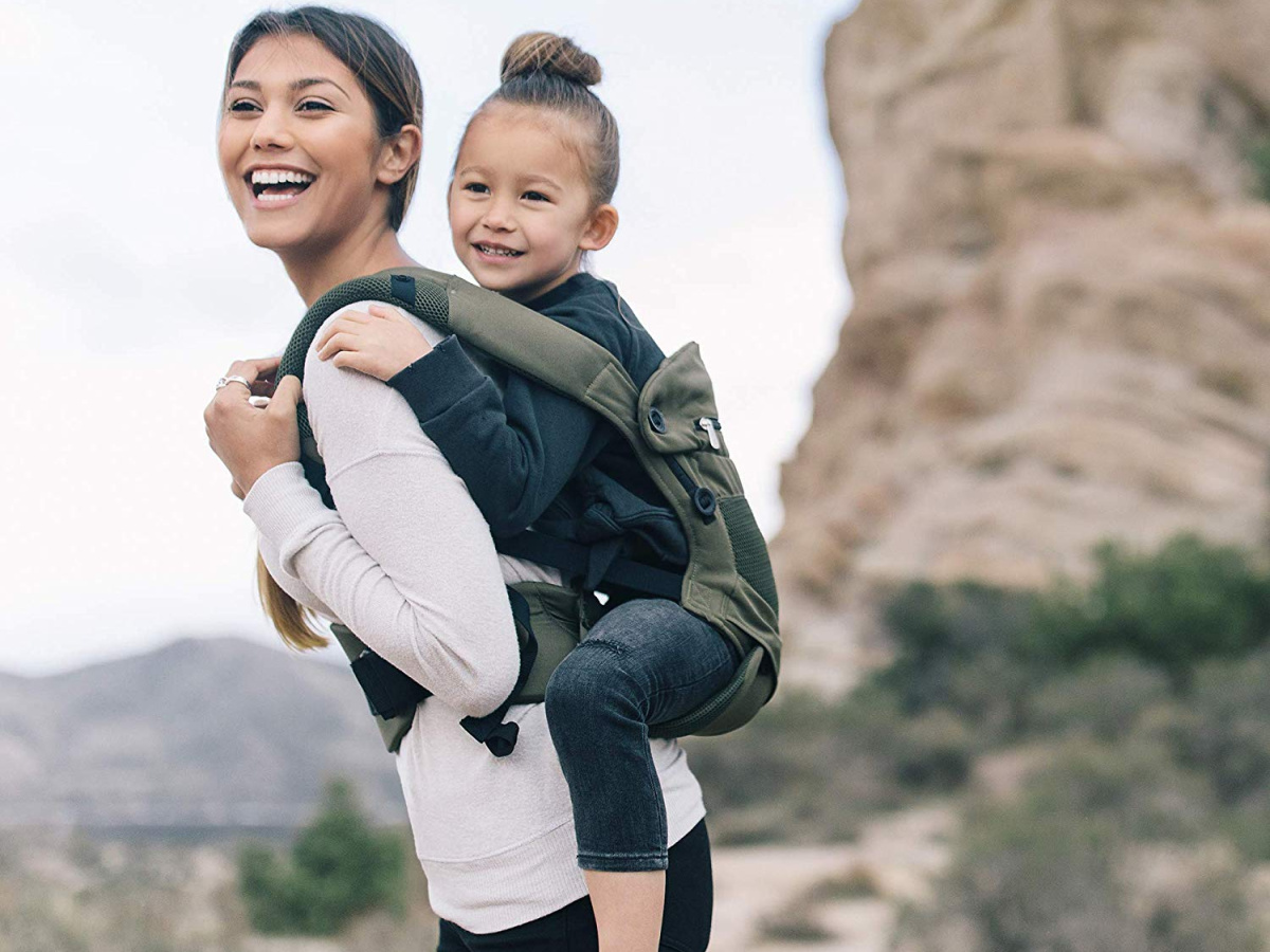 woman wearing child in carrier on her back