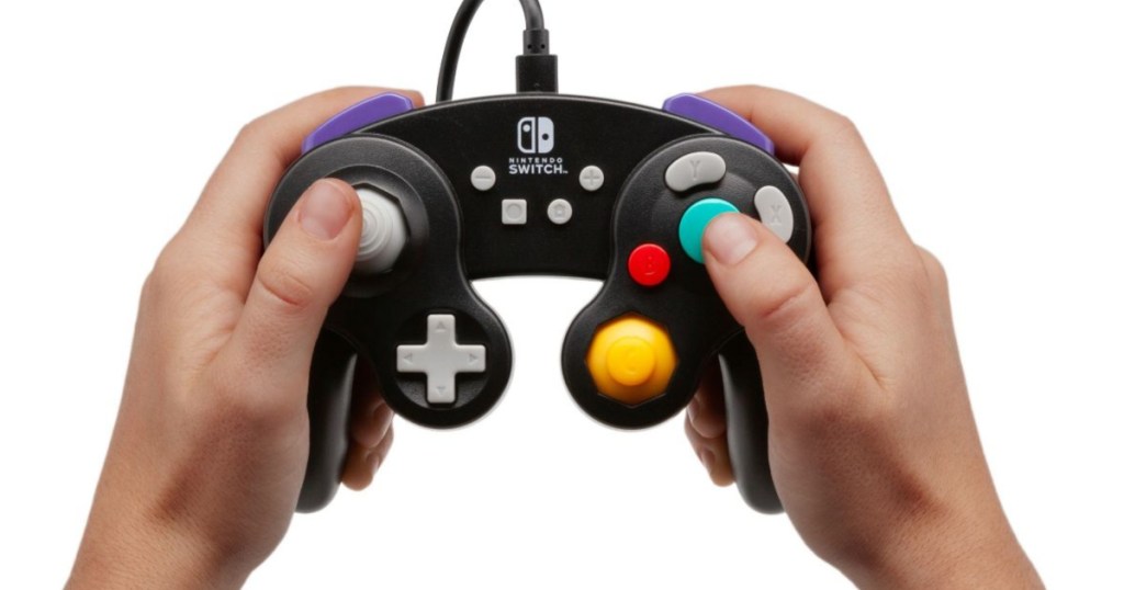 hands holding up black nintendo switch controller