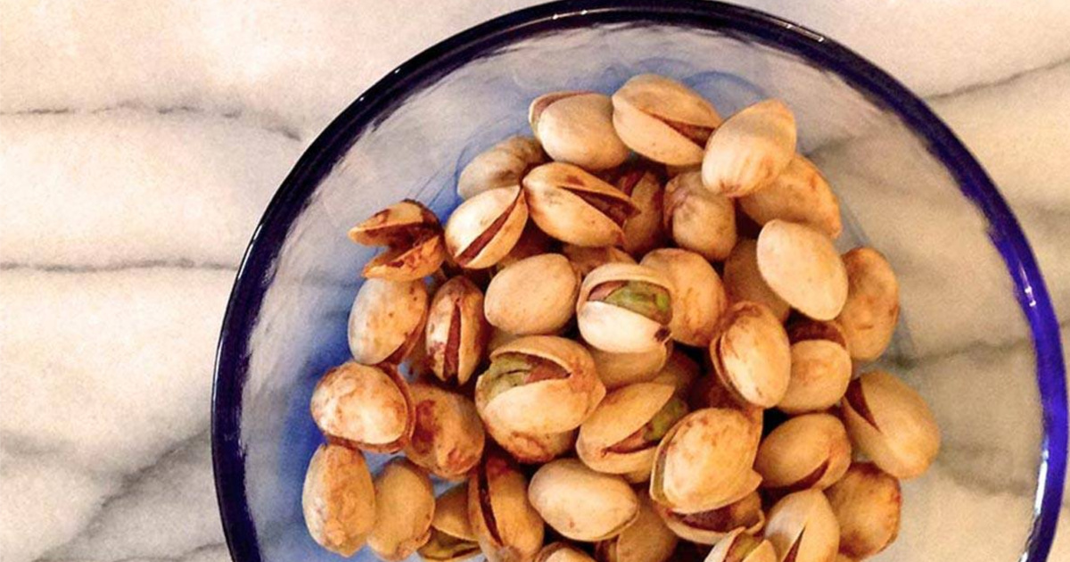 Glass bowl full of pistachios in-shell