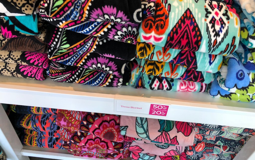 piles of floral throw blanket on store shelves