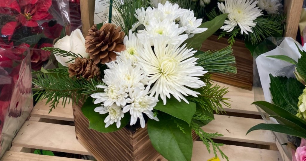 white flowers and pinecones in boxed arrangements