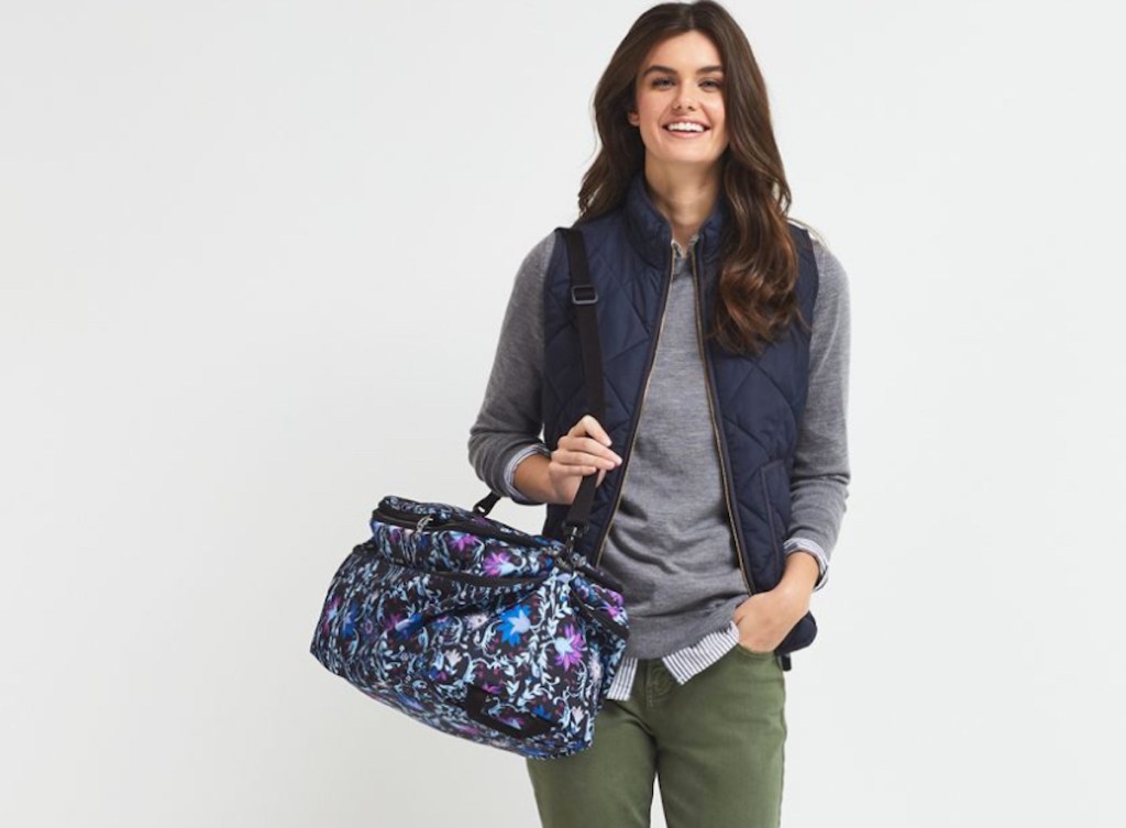 woman smiling holding floral vera bradley travel bag