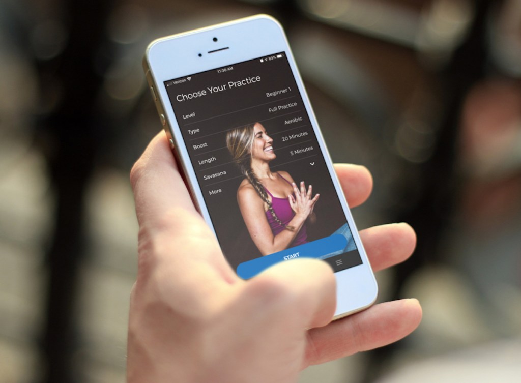 hand holding a phone with yoga app on screen 