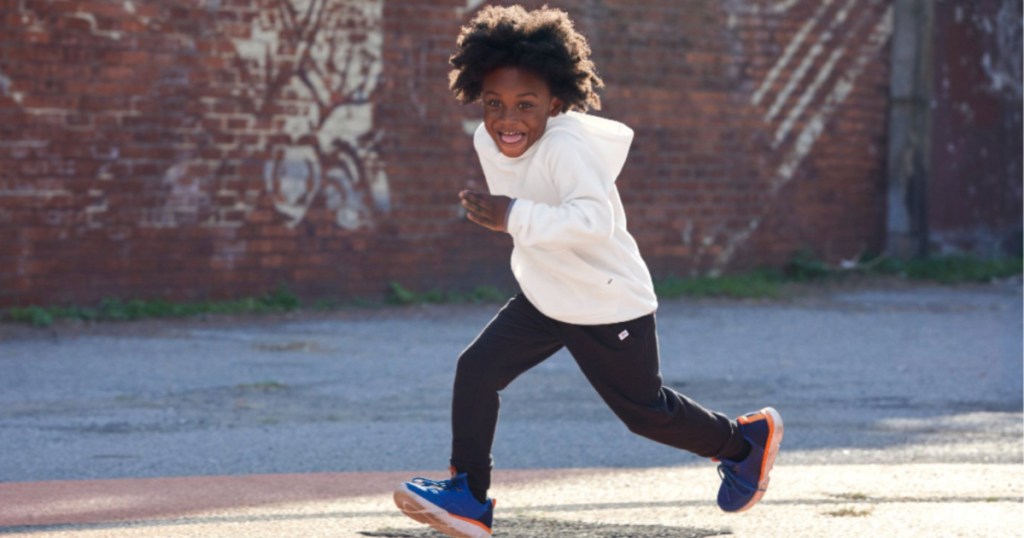 boy wearing white DSG Boys' Raglan Polar Fleece Hoodie running in the street outside