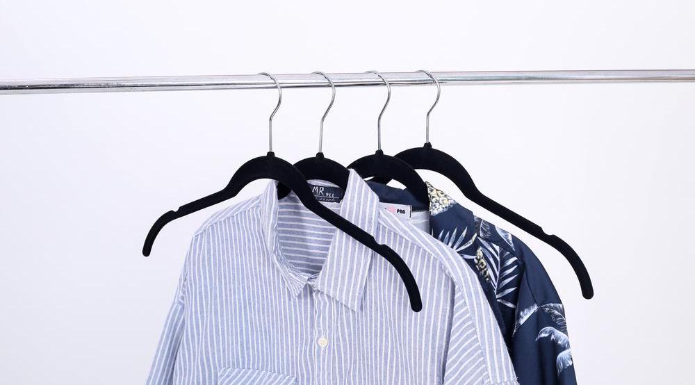 hangers on rack with shirts on them