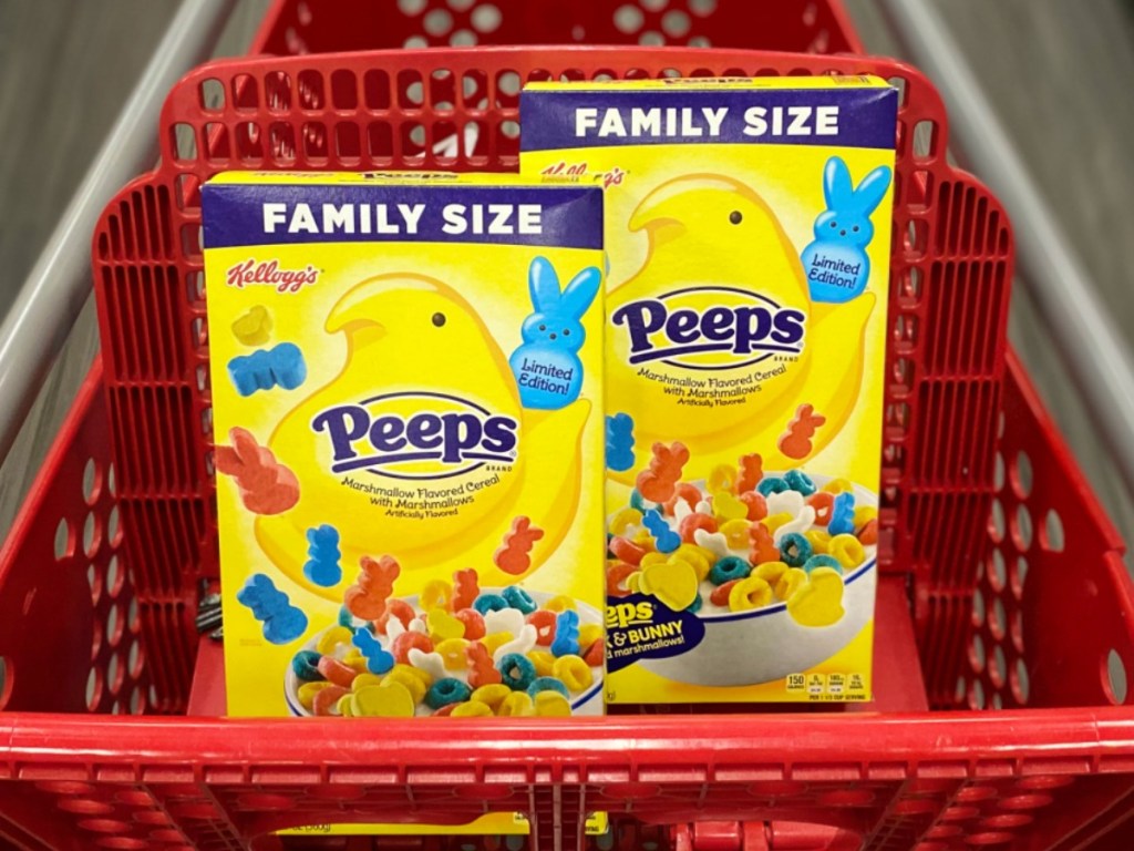 Two boxes of Peeps themed cereal in family size sitting in seat of red shopping cart, in store