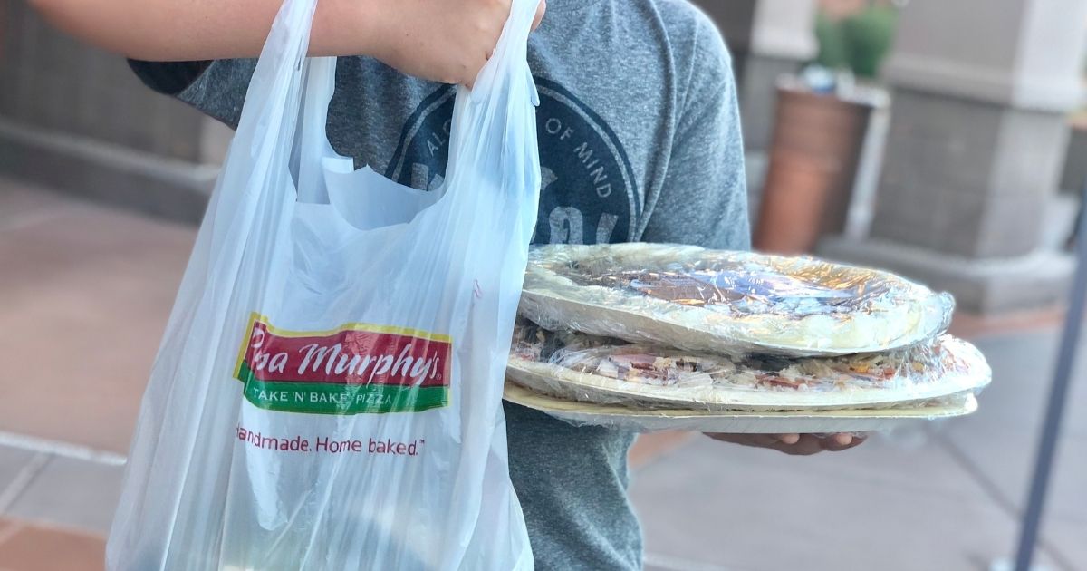 boy holding a Papa Murphy's bag and pizzas
